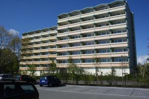 un grande edificio bianco con auto parcheggiate di fronte di Ferienappartement E417 für 2-4 Personen an der Ostsee a Schönberg in Holstein