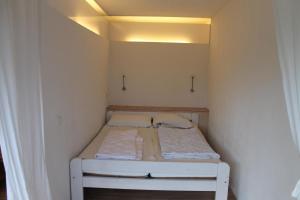 a small white bed in a small room at Ferienwohnung F225 für 2-5 Personen an der Ostsee in Brasilien