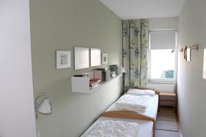 ブラズィリアンにあるFerienwohnung F419 für 2-4 Personen an der Ostseeのベッド2台と窓が備わる小さな客室です。