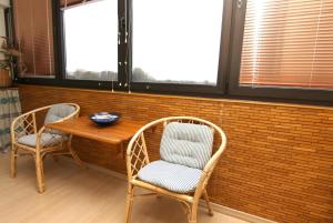 ブラズィリアンにあるFerienwohnung F326 für 2-4 Personen an der Ostseeの窓のある客室で、椅子2脚と木製テーブルが備わります。