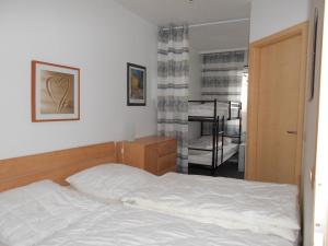 ブラズィリアンにあるFerienwohnung F402 für 2-4 Personen an der Ostseeのベッドルーム1室(ベッド1台付)、二段ベッド1組が備わります。