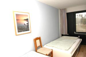 Cette chambre comprend 2 lits et une fenêtre. dans l'établissement Ferienwohnung F156 für 2-4 Personen an der Ostsee, à Brasilien