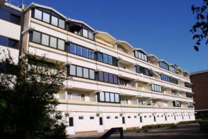 Un grand bâtiment blanc avec de nombreuses fenêtres dans l'établissement Ferienwohnung L408 für 2-4 Personen an der Ostsee, à Brasilien