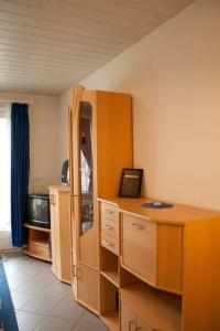 een kamer met een bureau, een kast en een televisie bij Ferienwohnung F127 an der Ostsee in Brasilien