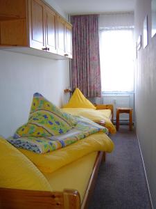 1 dormitorio con 3 camas con sábanas amarillas y ventana en Ferienwohnung L142 für 2-4 Personen an der Ostsee, en Brasilien