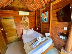 una camera con un letto in una cabina di legno di AKBAL Holbox - Beach Zone a Isola Holbox