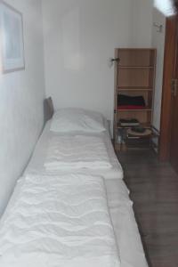- un lit blanc dans une chambre avec une étagère dans l'établissement Ferienwohnung V110 direkt am Ostseestrand, à Kalifornien
