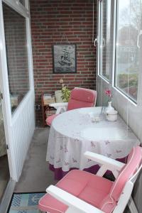 - une table et des chaises sur la terrasse couverte d'une maison dans l'établissement Ferienwohnung V110 direkt am Ostseestrand, à Kalifornien