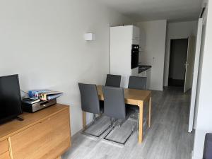 a dining room table with chairs and a television at Ferienwohnung L254 an der Ostsee in Brasilien