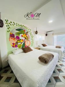 ヒリトゥラにあるK&M HOTELのベッド2台が備わる客室で、壁に看板が付いています。