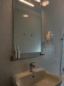 a bathroom with a sink and a mirror at La Veronica Apartment in Naples