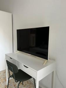 ein weißer Schreibtisch mit einem TV darüber in der Unterkunft La Veronica Apartment in Neapel