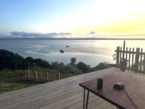 a table on a deck with a view of the water at Whatuwhiwhi View in Karikari Peninsula