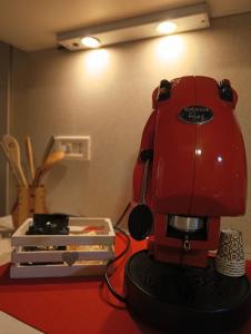 a red coffee maker sitting on a table at Onboarding! in Naples