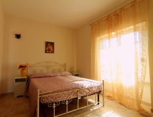a bedroom with a bed and a large window at Country Salenthouse in Marina di Mancaversa +17 photos