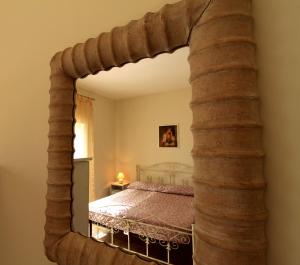 a large mirror in a bedroom with a bed at Country Salenthouse in Marina di Mancaversa