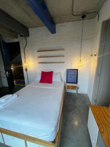 1 dormitorio con cama blanca grande y almohada roja en Indie Studio, en Medellín