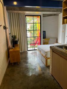 1 dormitorio con cama, ventana y lavamanos en Indie Studio, en Medellín
