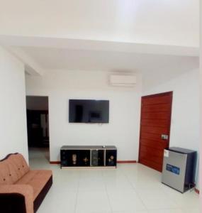 ein Wohnzimmer mit einem Sofa und einem TV in der Unterkunft D'eluxe Hotel Talara ubicado a 5 minutos del aeropuerto y a 8 minutos del Centro Civico in Talara