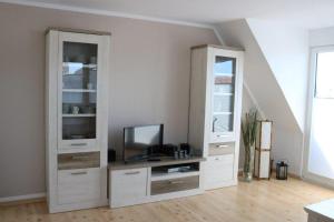 a living room with white cabinets and a tv at Am Kampland 25b in Dahme
