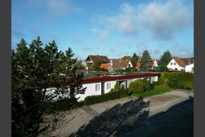 a white building with a red roof in a yard at Am Kampland 25b in Dahme