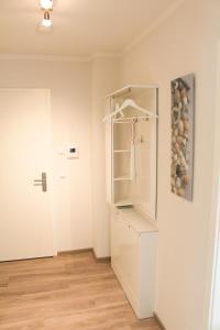 a white refrigerator in a room with a door at Zur Strandwiese W6 in Dahme