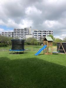 een speeltuin met een blauwe glijbaan en een speelstructuur bij Zur Strandwiese W6 in Dahme