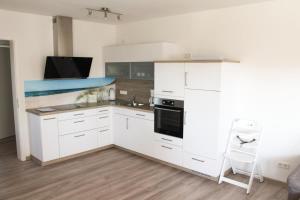 a kitchen with white cabinets and a stove at Zur Strandwiese W2 in Dahme