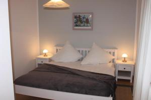 een slaapkamer met een bed met twee nachtkastjes en twee lampen bij Jacobihof Haus 3 Wohnung 01 in Dahme