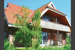 een huis met twee tafels en stoelen ervoor bij Jacobihof Haus 3 Wohnung 01 in Dahme