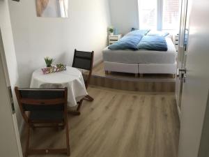 a bedroom with a bed and a table and a chair at Seeblick 1 in Dahme