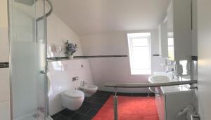 a white bathroom with a toilet and a sink at Seeblick 1 in Dahme