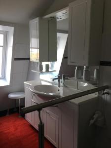 a white bathroom with two sinks and a window at Seeblick 1 in Dahme