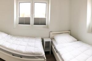 two beds in a room with two windows at Zur Strandwiese W1 in Dahme