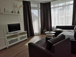 a living room with a couch and a television at Strandhotel Wohnung 2 in Dahme