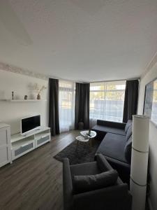 a living room with a couch and a tv at Strandhotel Wohnung 2 in Dahme
