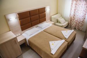 1 dormitorio con 1 cama grande y 1 silla en Santa Rosa Hotel & Beach, en Alexandroupoli