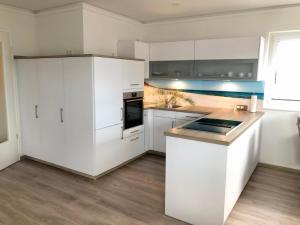 a kitchen with white cabinets and a counter top at Zur Strandwiese W5 in Dahme