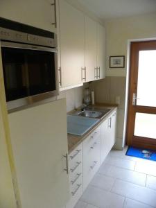 a kitchen with white cabinets and a sink at Jacobihof Haus 9 Wohnung 02 in Dahme