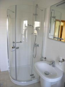 a white bathroom with a shower and a sink at Jacobihof Haus 9 Wohnung 02 in Dahme