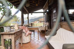 a porch with a table and chairs and a view of a mountain at Bela Ilha Guest House in Ilhabela