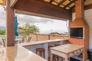 an outdoor kitchen with a table and a counter top at Bela Ilha Guest House in Ilhabela