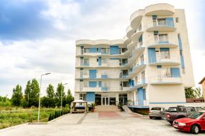 un edificio con auto parcheggiate di fronte di Babylonia Resort a Costinesti