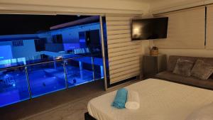 Habitación con cama y ventana con TV. en PISCINA SARITA CLUB BOUTIQUE, en Girardot