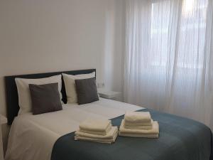 una camera da letto con un letto e asciugamani di Anduriña a Vigo
