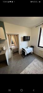 a living room with a white table and a window at T2 proche gare avec wifi 1er étage in Chartres