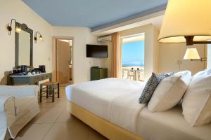 a bedroom with a bed with a view of the ocean at Sissi Bay Resort in Sisi