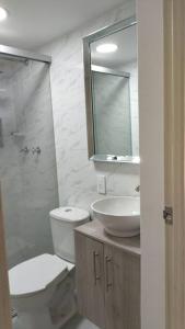 a bathroom with a toilet and a sink and a mirror at Apartamento in Medellín