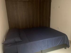 uma cama num quarto com um armário de madeira em Alojamiento en Medellín em Medellín