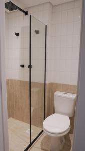 a bathroom with a toilet and a glass shower at Apê Pátio Paulista in Sao Paulo